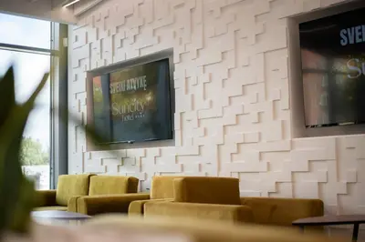 a waiting room with couches and a tv on a wall at Suncity Hotel & SPA in Šiauliai