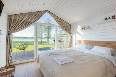 a bedroom with a bed and a large window at Comfort Villas in Ukmergė