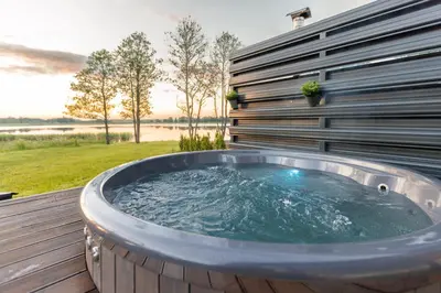 a hot tub on the deck of a house at Comfort Villas in Ukmergė