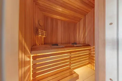 a sauna with wooden walls and a wooden floor at Comfort Villas in Ukmergė