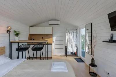 a room with a bed and a kitchen with a counter at Comfort Villas in Ukmergė