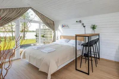 a bedroom with a bed and a large window at Comfort Villas in Ukmergė
