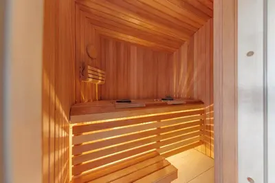 a sauna with wooden walls and a wooden floor at Comfort Villas in Ukmergė