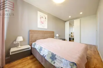 a bedroom with a bed and a lamp on a night stand at Sausio 13 Apartamentas in Vilnius