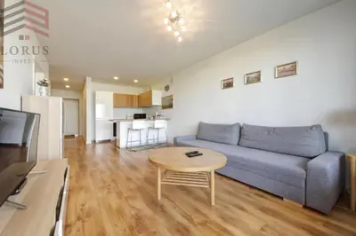 a living room with a blue couch and a table at Sausio 13 Apartamentas in Vilnius