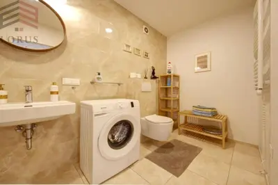 a bathroom with a washing machine and a sink at Sausio 13 Apartamentas in Vilnius