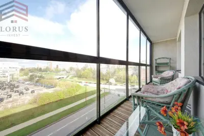 a balcony with a chair and a view of a street at Sausio 13 Apartamentas in Vilnius