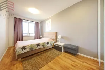 a bedroom with a bed and a chair in it at Sausio 13 Apartamentas in Vilnius