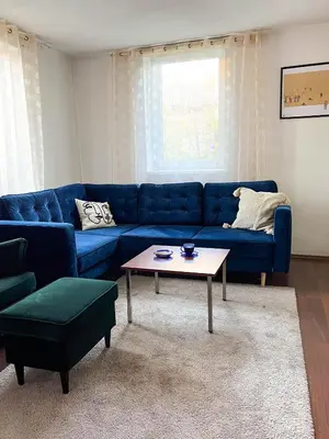 a living room with a blue couch and a coffee table at GreenHill House in Kaunas