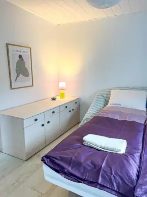 a bedroom with a purple bed and a dresser at GreenHill House in Kaunas