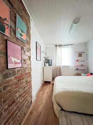 a bedroom with a brick wall and a bed at GreenHill House in Kaunas