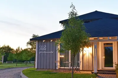 a small shed with a table and chairs in a yard at Cozy stay by Kaunas vila 9Vėjai in Girininkai