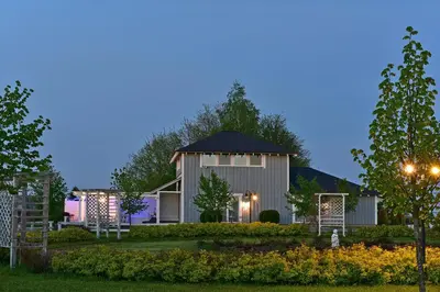a barn with a garden at night at Cozy stay by Kaunas vila 9Vėjai in Girininkai