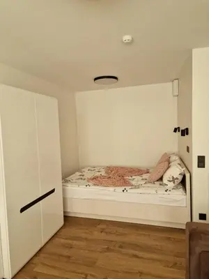 a small bedroom with a bed in the corner at Apartamentai AKVIJOLA in Vilkaviškis