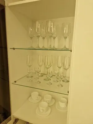 a bunch of wine glasses sitting on shelves at Apartamentai AKVIJOLA in Vilkaviškis