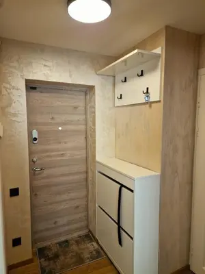 a small kitchen with a refrigerator and a door at Apartamentai AKVIJOLA in Vilkaviškis