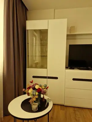 a living room with a table with flowers on it at Apartamentai AKVIJOLA in Vilkaviškis