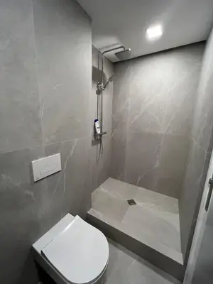 a bathroom with a white toilet and a shower at Peaceful Apartment Lazdynai in Vilnius