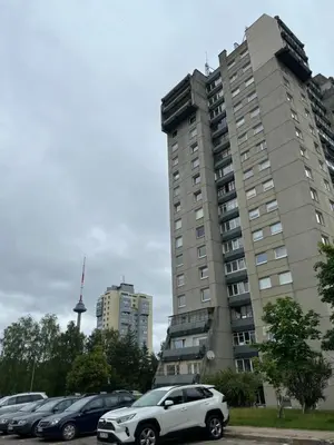 a white car parked in front of a tall building at Peaceful Apartment Lazdynai in Vilnius