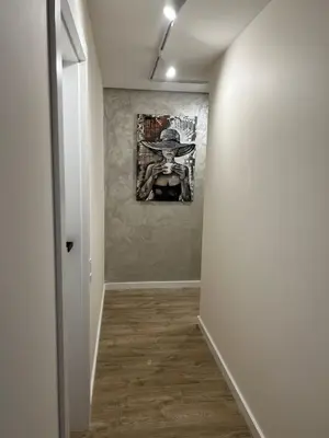 a hallway with a painting on the wall at Peaceful Apartment Lazdynai in Vilnius