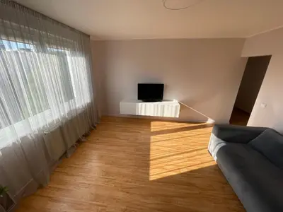 a living room with a couch and a television at Karoliniškių apartamentai in Vilnius