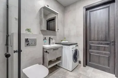 a bathroom with a washing machine and a sink at cohost I Newly Built Apartments by Historical Bastion Wall, Self check in in Vilnius