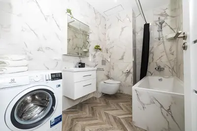 a white bathroom with a washing machine in it at cohost I Newly Built Apartments by Historical Bastion Wall, Self check in in Vilnius