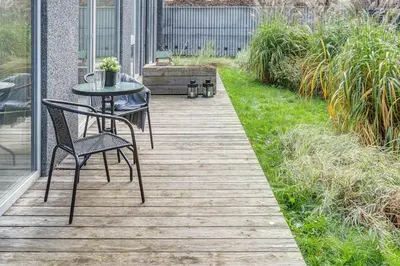 a wooden deck with a table and chairs on it at cohost I Newly Built Apartments by Historical Bastion Wall, Self check in in Vilnius