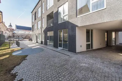 a building with a brick sidewalk next to a building at cohost I Newly Built Apartments by Historical Bastion Wall, Self check in in Vilnius