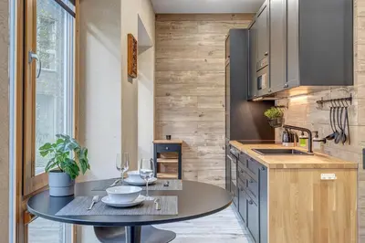 a kitchen with a table with wine glasses on it at cohost I Newly Built Apartments by Historical Bastion Wall, Self check in in Vilnius
