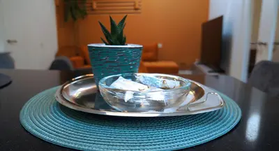 a plate with a bowl on a table with a vase at Daina Apartments Self check-in in Vilnius