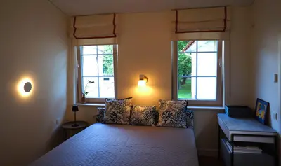 a bedroom with a bed with two windows at Daina Apartments Self check-in in Vilnius