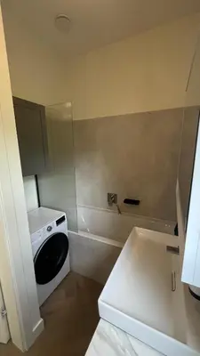 a laundry room with a washing machine and a sink at Daina Apartments Self check-in in Vilnius