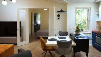 a kitchen and living room with a table and chairs at Daina Apartments Self check-in in Vilnius