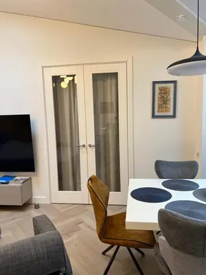 a living room with a table and chairs and a tv at Daina Apartments Self check-in in Vilnius