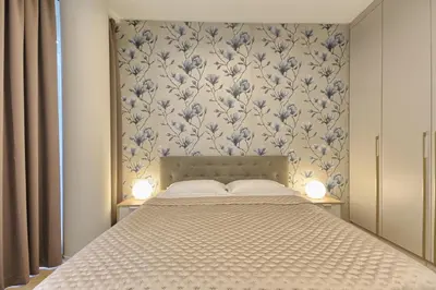 a bedroom with a bed with a floral wallpaper at Ruby Rest in Druskininkai