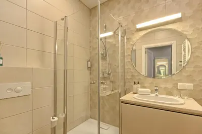 a bathroom with a shower and a sink and a mirror at Ruby Rest in Druskininkai