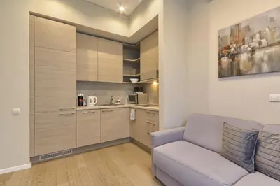 a living room with a couch and a kitchen at Ruby Rest in Druskininkai
