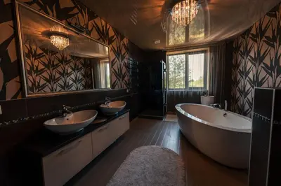 a bathroom with two sinks and a tub and mirrors at Paežerės istorijos near Druskininkai in Veršiai