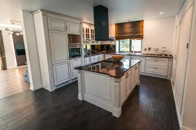 a large kitchen with white cabinets and a large island at Paežerės istorijos near Druskininkai in Veršiai
