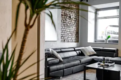 a living room with a black couch and a table at Hales Old Town Urban Apartments in Vilnius