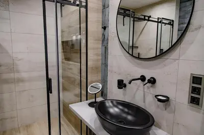 a bathroom with a black sink and a mirror at Hales Old Town Urban Apartments in Vilnius