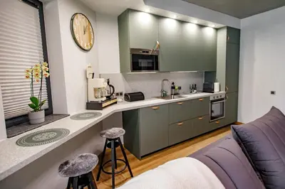 a kitchen with green cabinets and a counter top at Hales Old Town Urban Apartments in Vilnius