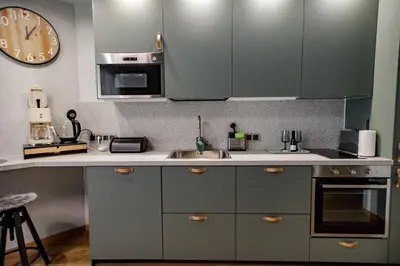 a kitchen with a sink and a clock on the wall at Hales Old Town Urban Apartments in Vilnius