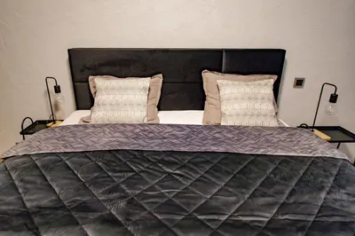 a large bed with a black headboard and two pillows at Hales Old Town Urban Apartments in Vilnius