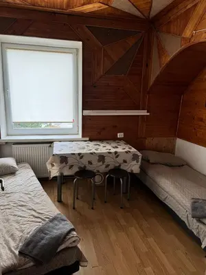 a bedroom with a table and two beds in it at Svečių Namai Darželis in Šiauliai