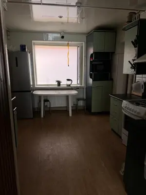 a kitchen with a white table and a window at Svečių Namai Darželis in Šiauliai