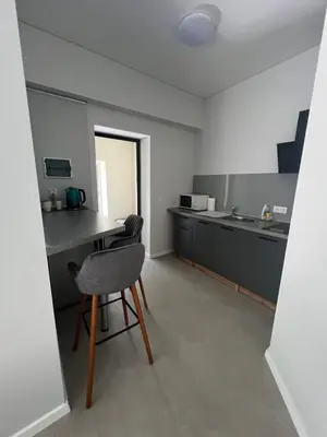 a kitchen with a table and a chair in a room at Mintare in Šveicarija