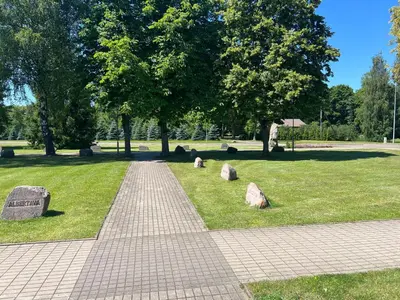 a walkway in a park with rocks in the grass at Mintare in Šveicarija