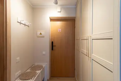 a hallway with a door and a bench next to it at Harmony Hill Apartments in Druskininkai